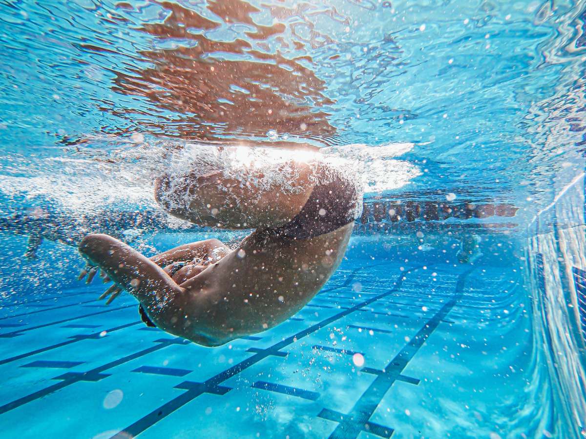 Child swimming underwater, illustrating that behaviour often reflects deeper needs beneath the surface.